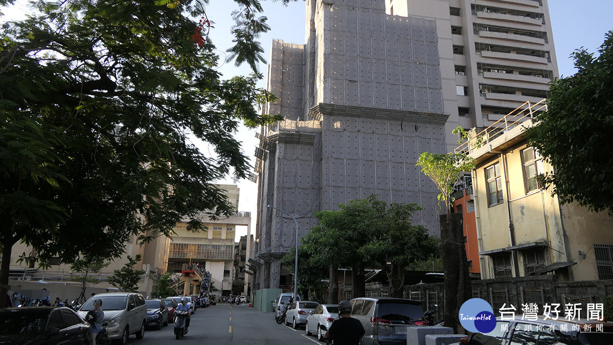 第一銀行台中分行外牆進行整修施工,現場搭設鷹架及防護網。