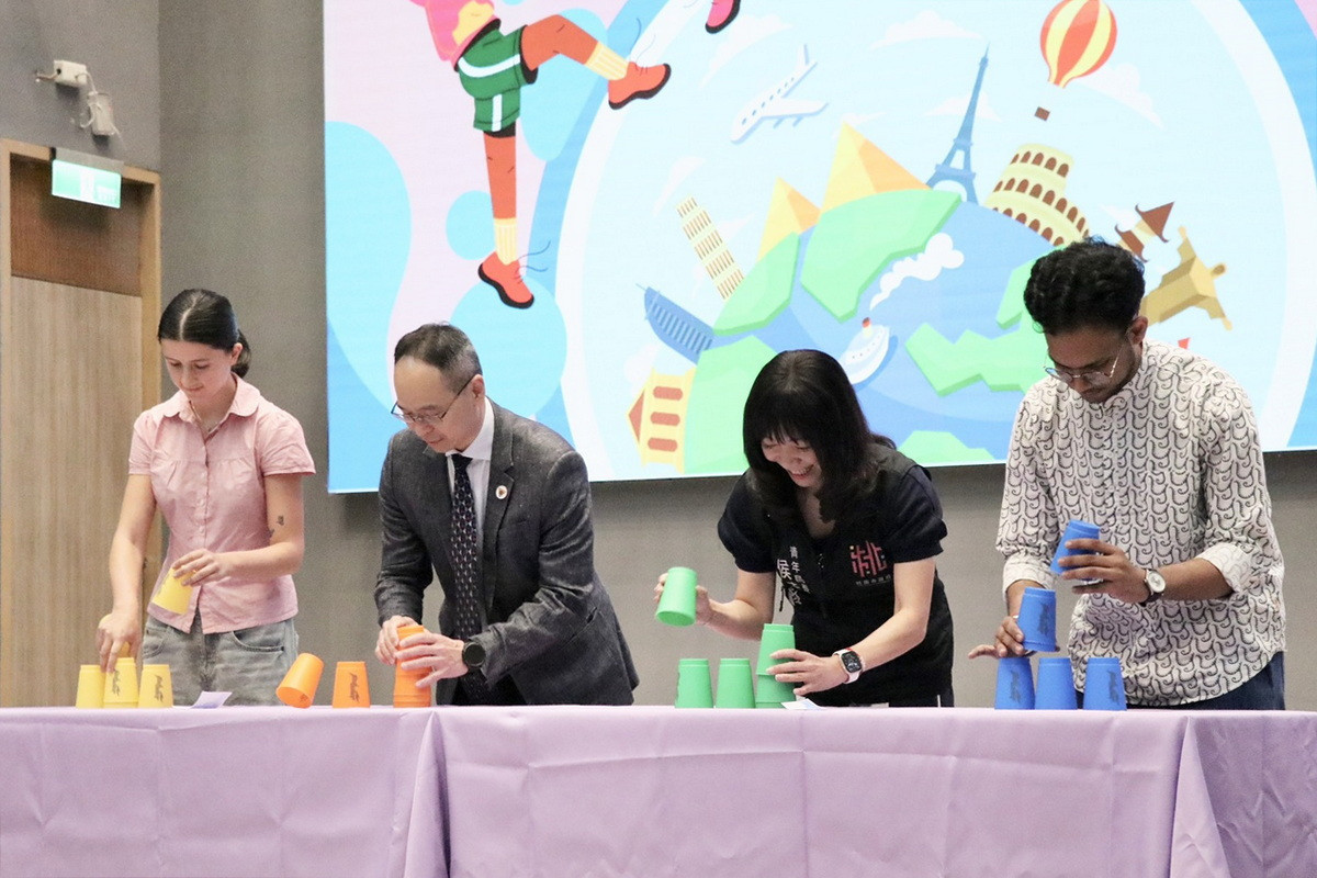 青年局長侯佳齡、國立中央大學副校長阮啟弘及國際學生一同體驗疊杯競賽。