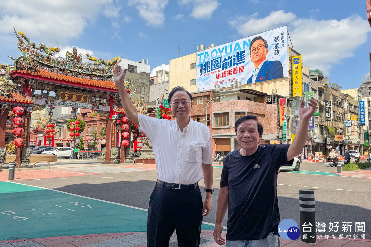 桃園市長張善政和國寶畫師謝森山於景福宮旁競選看板前合影。<br />
