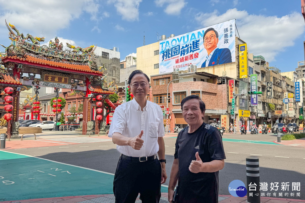 桃園市長張善政和國寶畫師謝森山於景福宮旁競選看板前合影。<br />
