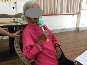 蔣奶奶在石岡區老人日間照顧中心志工的照顧之下，心情開朗的唱起歌來。（記者黃玉鼎攝）