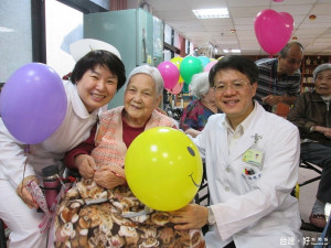 徐錦池院長致氣球與蘋果，為九月壽星住民慶生，並與來院就醫的病友宣導運動對健康的重要性。（圖／記者黃村杉攝）