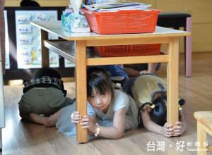 學童練習地震發生時蹲下、掩護、穩住3個要領進行避難，熟悉臨災時的自救保命技能。（記者陳昭宗拍攝）