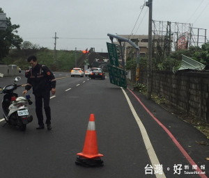 台19南下大型指示看版不敵梅姬狂風攔腰折斷，北港警方冒雨實施交通管制，並通知公路局派員處理。（記者陳昭宗拍攝）
