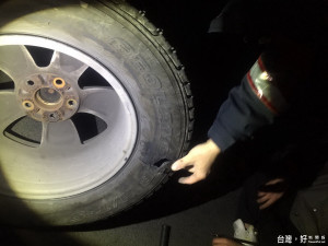 遊客車輛陷入路旁水溝中爆胎而受困，武陵小隊員警趕抵協助換胎脫困。（圖／保七總隊第五大隊提供）