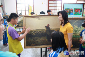 李翊愷同學向李孟珍處長介紹大師的畫作。（記者扶小萍攝）