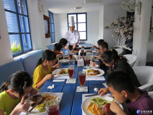 范文康宴請家境清寒的小朋友吃西餐牛排。