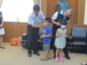 在地企業捐贈口罩給縣府，縣長與捐贈者為孩童戴上。（記者許素蘭／攝）