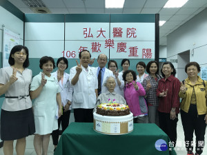 欣逢重陽節前夕，弘大醫院院長鍾蝶起（左四）特別致贈蛋糕，慶賀百歲人瑞重新站起來。（醫院提供）