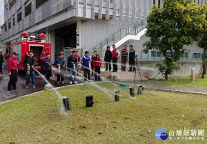 消防局指導業者操作水滅火器。（圖／記者郭文君攝）