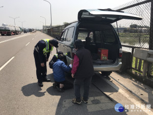 警員幫廂型車蔡姓駕駛換備胎。

