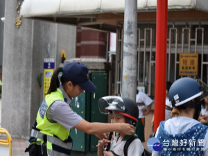 女警指導小朋友正確使用安全帽。林重鎣攝