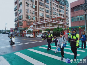 楊梅分局草湳派出所的警察姐姐冒著綿綿細雨在路口守護交通安全。