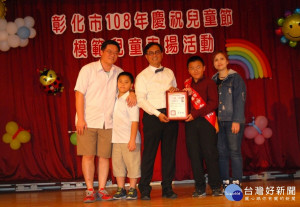 彰化市長林世賢逐一和接受表揚的模範兒童全家福合影留念。圖／彰化市公所提供)