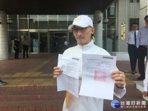 江欽良出示不起訴處分書檢方送請再議被駁回。（記者扶小萍攝）