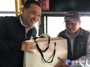 獲選今年度優良公車駕駛的蔡仁生，有著原住民的樂觀天性，擔任公車駕駛13年以來，總是把乘客的安全擺第一；侯友宜趁著搭乘機會贈禮表達感謝 。（圖／交通局提供）