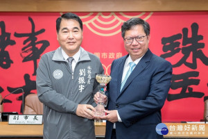 桃園市長鄭文燦接受市府水務局長劉振宇呈獻的「107年度水患自主防災社區評鑑績優縣市」獎座。
