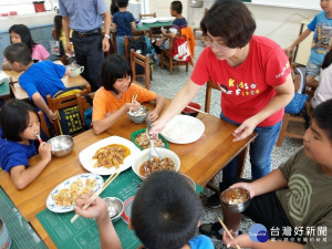 魏主任為課輔班的學童盛菜。