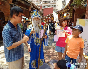 深坑分館主任楊俊生特別利用假日，巧扮成土地公，於老街上發送書香籤詩