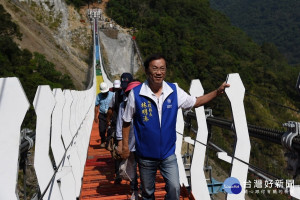 林縣長行走在吊橋上感受峽谷峭壁的壯觀之美。
