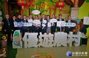 參與來賓手持優遊農村及農村好物手牌合影。〈記者吳素珍攝〉