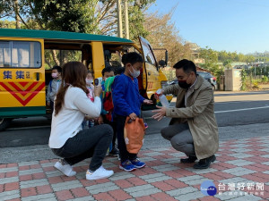 鎮長陳紀衡現身站上第一線，為孩童進行體溫量測、酒精消毒。
