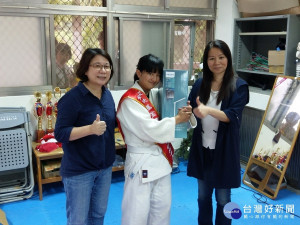 同富國中代理校長許淑春(右一)與南投家扶中心主任魏季李(左一)頒贈全國自強兒童南投傑出代表蔻蔻霂．伊斯卡卡夫特(中)