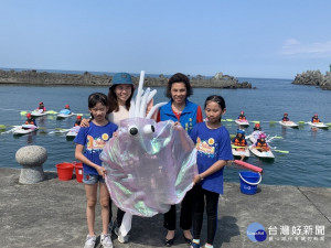 野柳國小12日於野柳海王星碼頭辦理獨木舟薪傳畢業活動，畢業生與在校生身背自製的軟絲公仔，操划獨木舟進入會場，宣誓復育軟絲、維護海洋生態