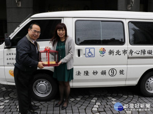 社會局副局長林昭文（左）將復康巴士模型車交由匯豐汽車南港所長呂筱晴  請她代為轉送
