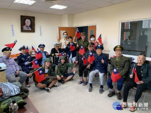 著軍服揮著國旗的失智長輩們跟著螢幕歌詞與旋律高聲唱出國歌及「中華民國頌」、「梅花」、「夜襲」、「九條好漢在一班」等愛國與軍歌曲目 