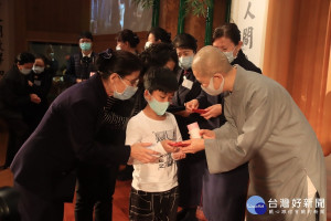 德宿德璒師父贈送學童福慧紅包和存錢筒。（記者扶小萍攝）