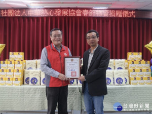 新北市榮民服務處林火土處長(左)回贈感謝狀，由中華熱心發展協會常務理事張志綸代表接受