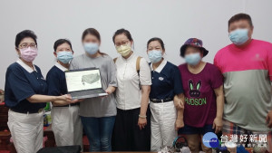 同學獲全新筆電高興與慈濟志工合影。（慈濟基金會提供）