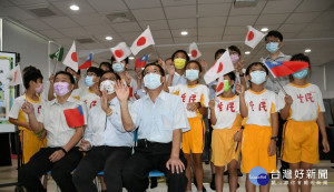 彰化市與日本姐妹市小松市完成視訊後林世賢市長（前排中）和小朋友們持台日國旗向日方揮手再見。圖／彰化市公所提供