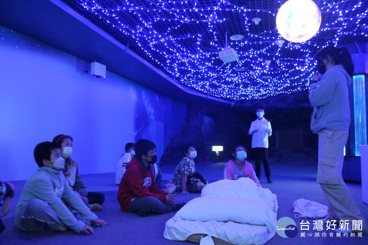花蓮家扶中心小朋友參加親親海洋夜未眠-指導員正在示範鋪床。