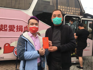 邱姓民眾排得第一位，莊主委加贈金錢母一枚並以紅包袋包裝，既喜氣又獲土地公保佑。（記者扶小萍攝）