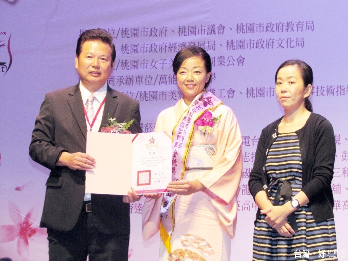 市長盃國際時尚造型競賽中,桃園市女子美容商業同業公會理事長謝錦明頒發感謝狀給日本國際毛髮與皮膚研究所代表理事本山典子