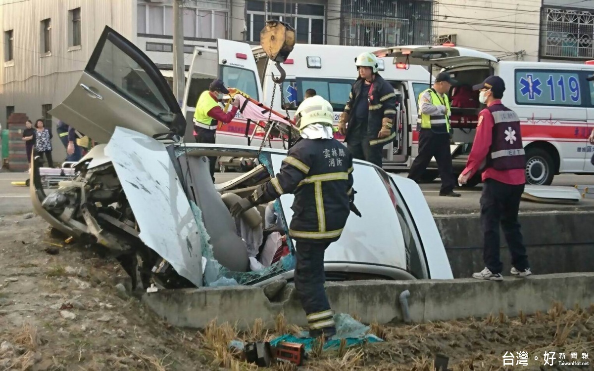 北港警消出動吊車將塞在水溝的自小客車吊起，並用切割器割開車門，將血跡斑斑的駕駛從車內救出。（記者蘇榮泉翻攝）