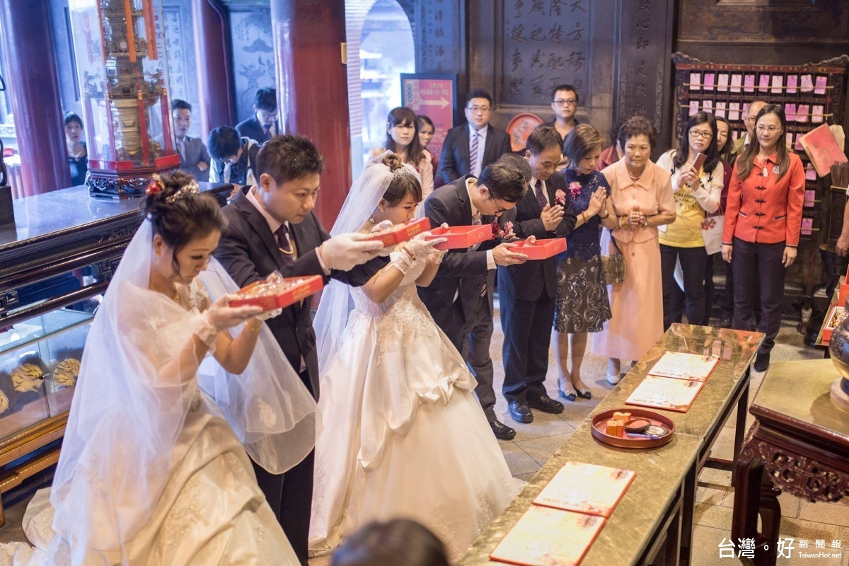 新人穿著婚紗在家人陪伴下攜帶喜餅等敬品敬拜媽祖,感謝媽祖賜福姻緣。(記者蘇榮泉攝)