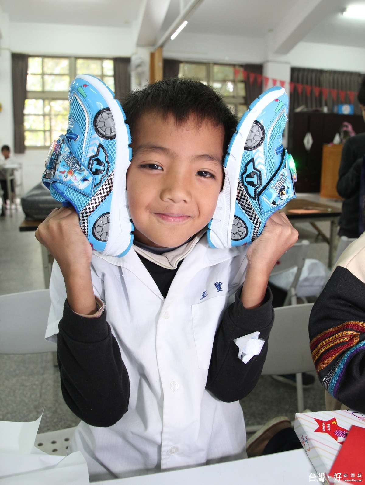 小朋友獲得球鞋的心願達成了，露出了滿足的笑容。