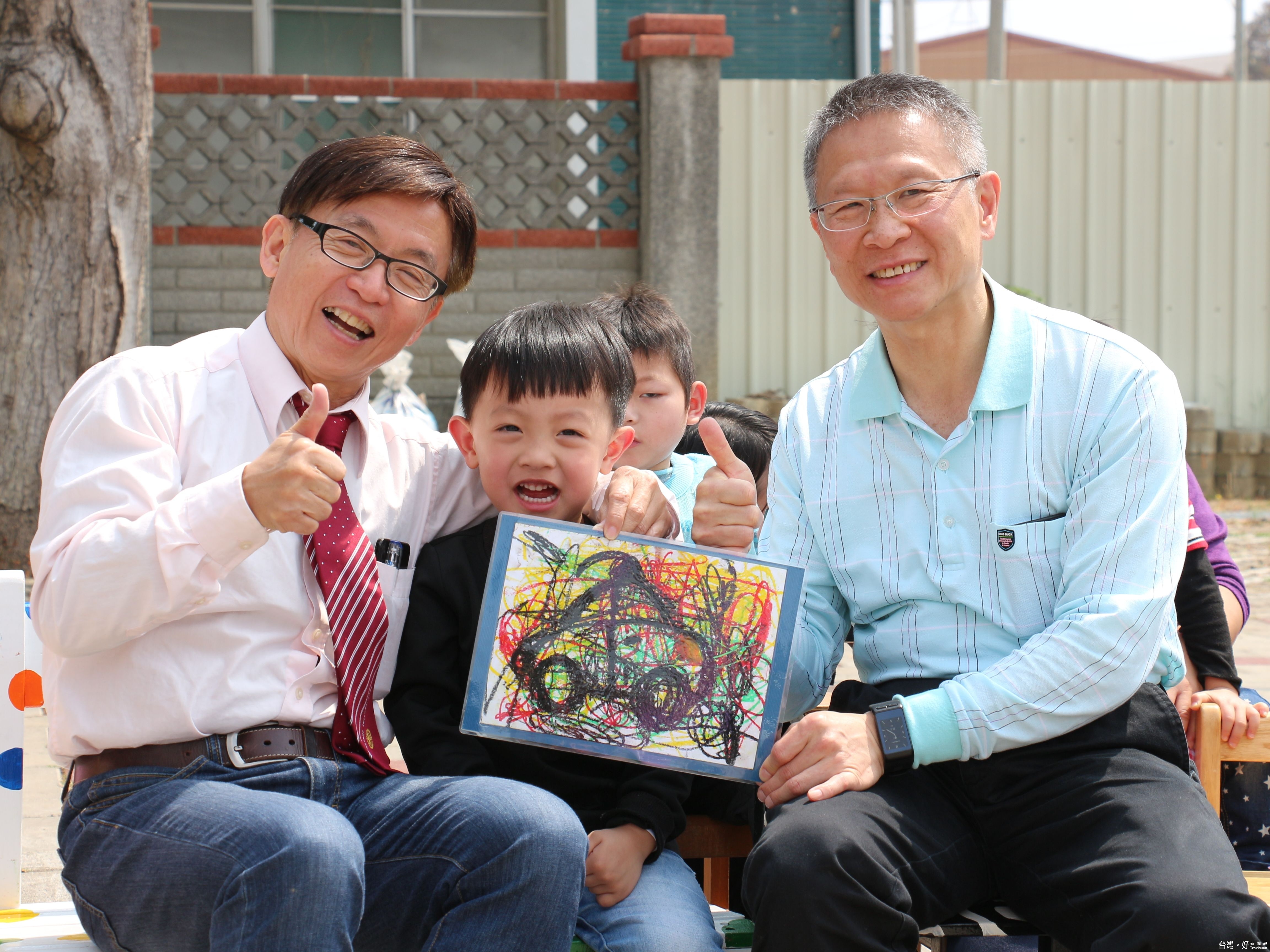 圖說3:孩子送上汽車畫作給許維新執行長(右),表達感謝。(左為雙福基金會執行長林茂安)