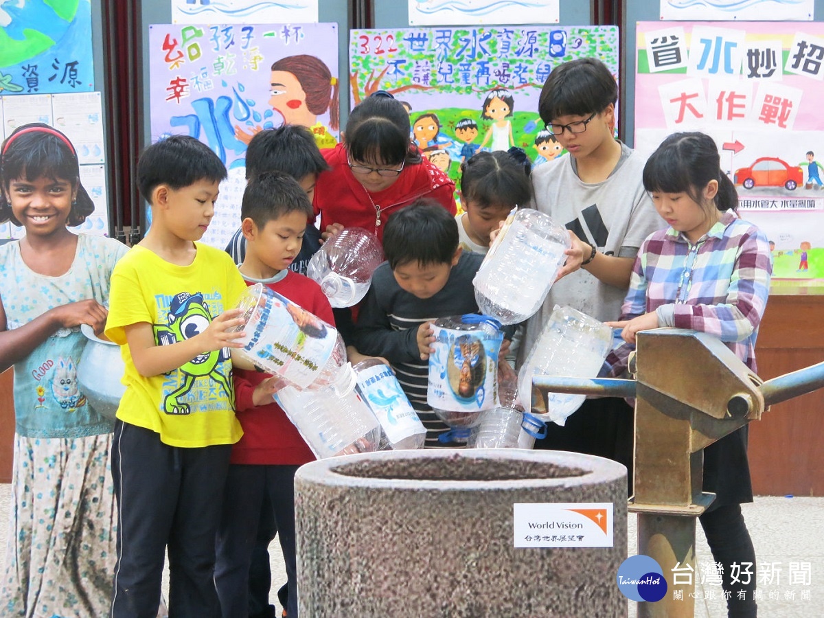 忠孝國小學生代表將水集中在水井裡，象徵送水到缺水國家去。