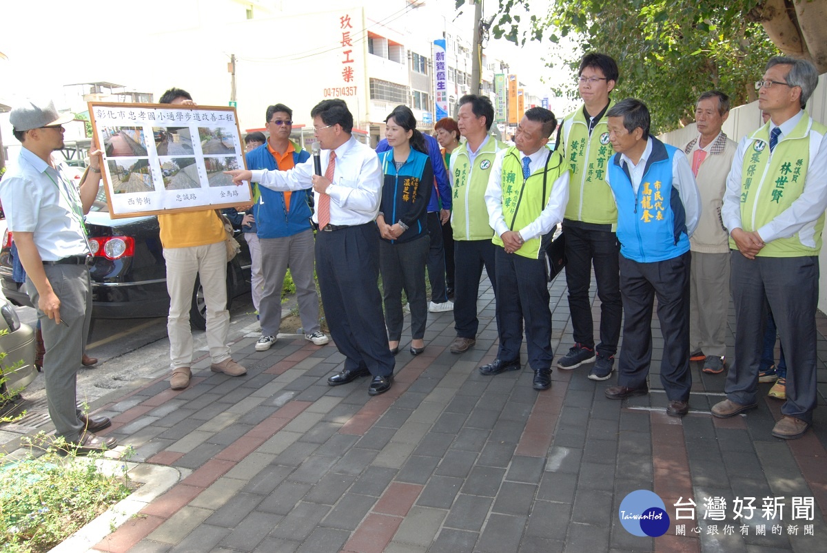 彰化市長邱建富說明忠孝國小通學步道改善工程改善前後的情況。