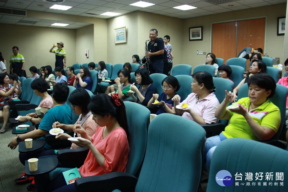 南投警察局女同仁分享蛋糕聆賞薩克斯風演奏。（記者扶小萍攝）