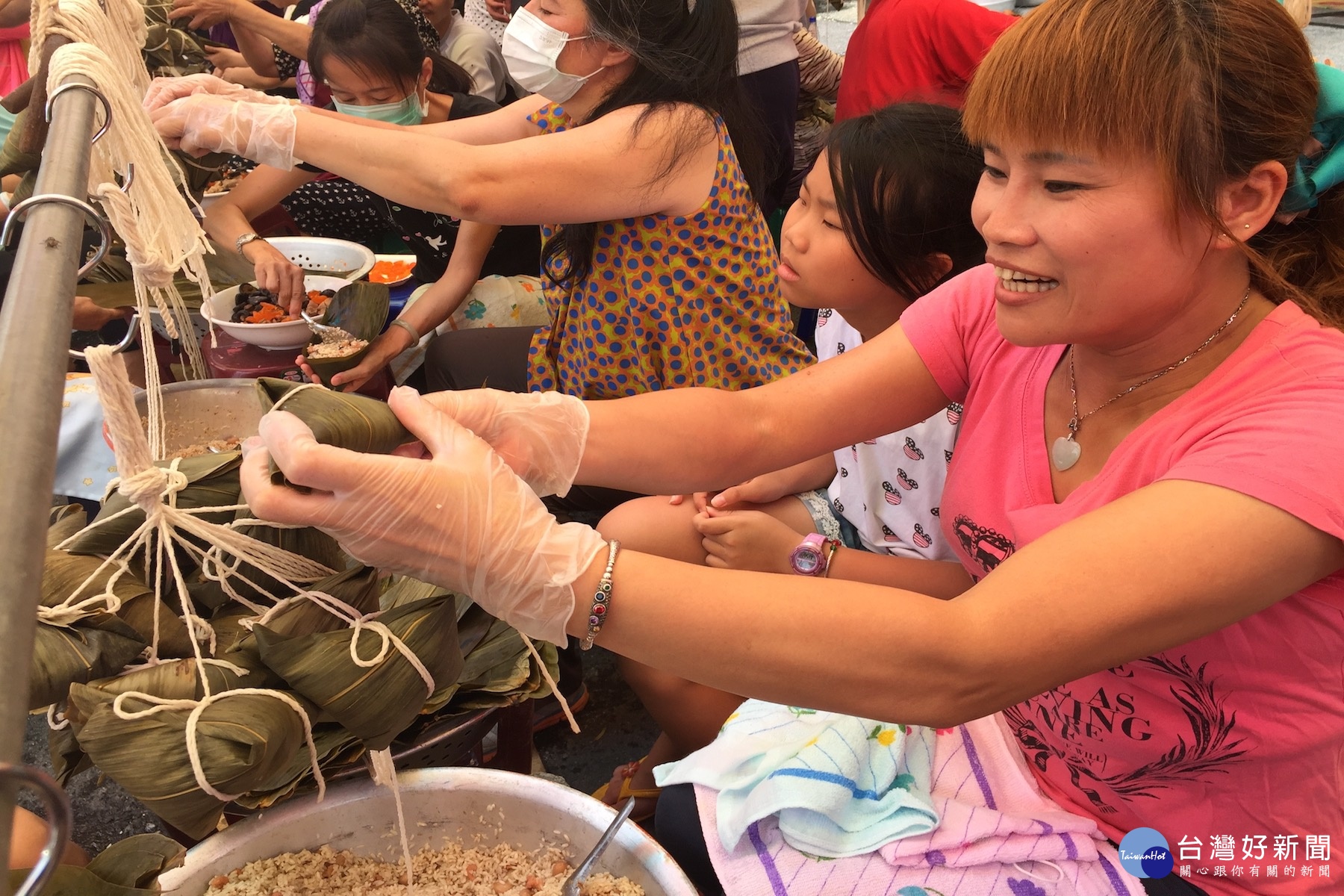 陸配林瑞蘭(右一)連續二年帶兩位兒女前來包愛心粽。(圖/記者黃芳祿攝) 