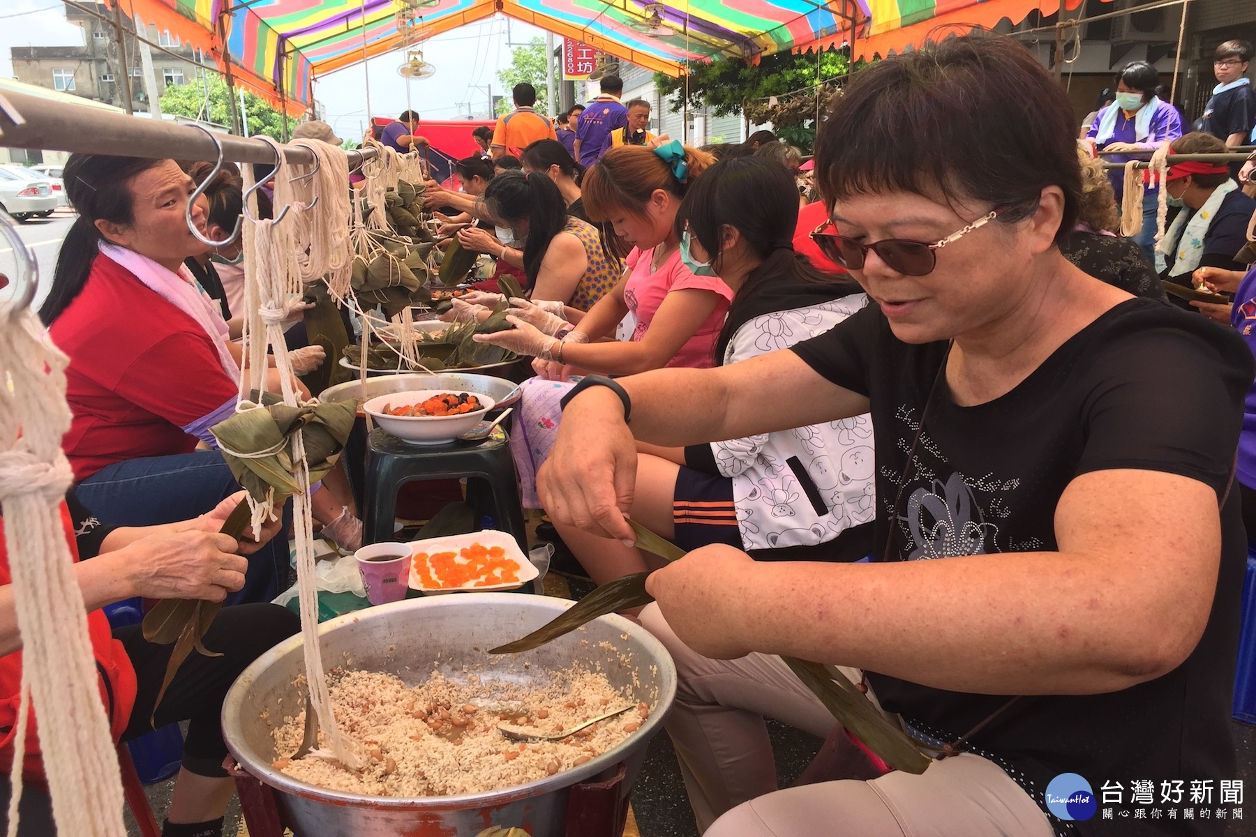 北家扶主任莊淑惠加入包愛心粽行列。(圖/記者黃芳祿攝) 