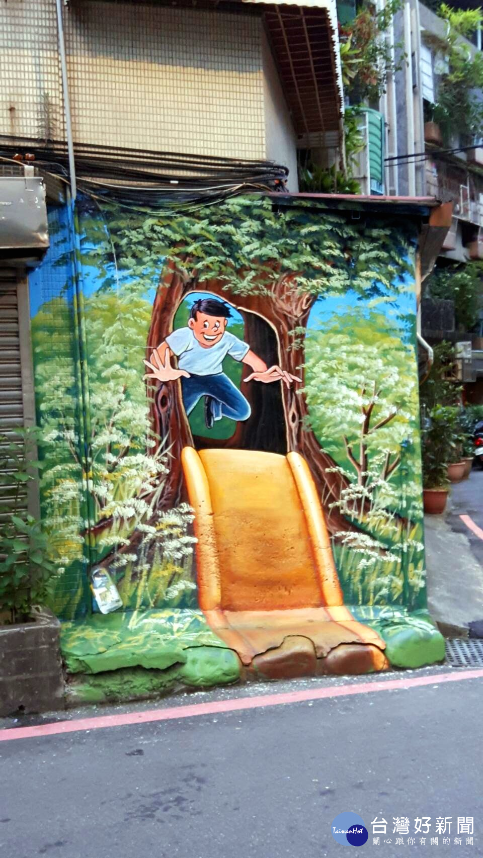 彩繪牆壁描繪小朋友開心的玩溜滑梯。（圖／記者黃竹佑攝）