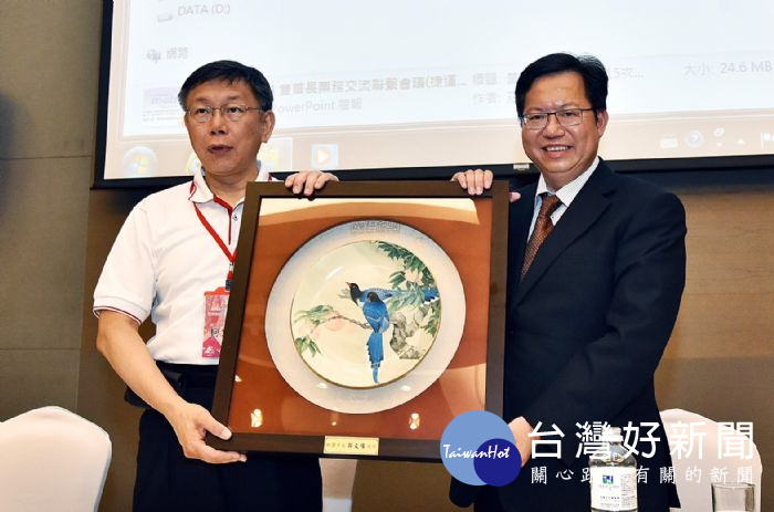 桃園市長鄭文燦與台北市長柯文哲互贈紀念品。