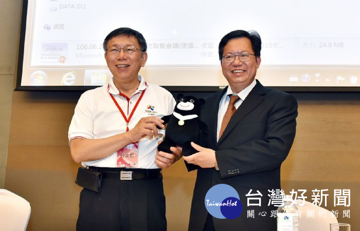 桃園市長鄭文燦與台北市長柯文哲互贈紀念品。
