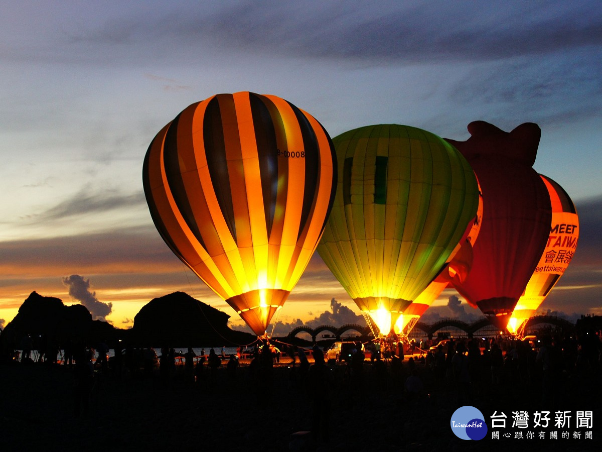 5顆豎立在三仙台鵝卵石上的熱氣球，搭配日出從海平面升起。（圖／台東縣政府提供） 